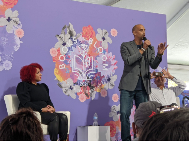 Baltimore native Marc Marcel performs poetry for the audience as Nikole Hannah-Jones and Busboys and Poets owner Andy Shallal watches from behind. (Aaron Wright/The Black Explosion)